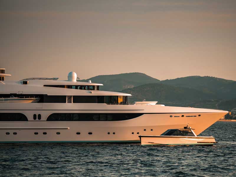 A superyacht and tender at sunset